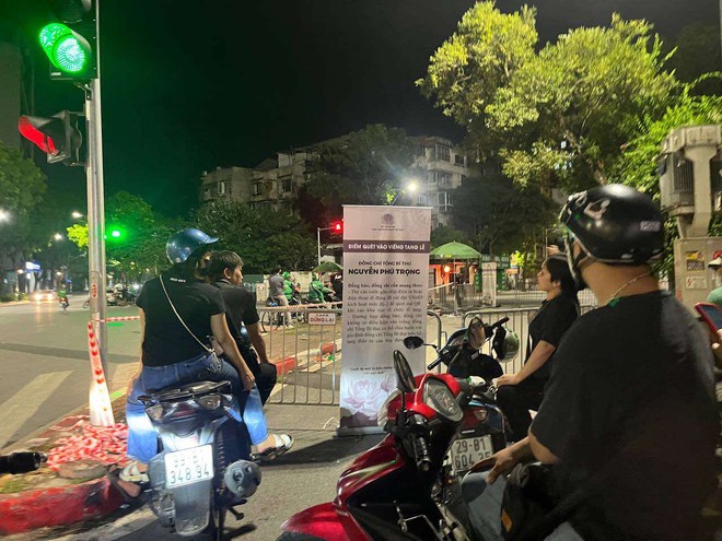 Nhiều người dân chờ thâu đêm trước cổng nhà tang lễ Quốc gia để được viếng Tổng Bí thư Nguyễn Phú Trọng vào sáng sớm- Ảnh 2. Nhiều người dân chờ thâu đêm trước cổng nhà tang lễ Quốc gia để được viếng Tổng Bí thư Nguyễn Phú Trọng vào sáng sớm- Ảnh 2.