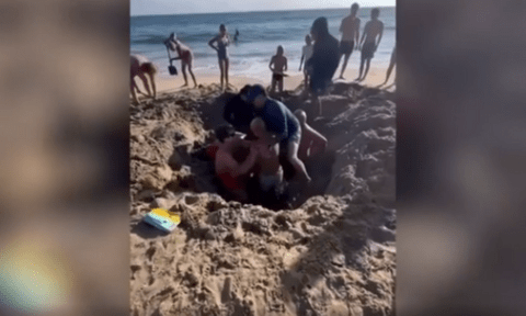 Clip: Sụt lún khi chơi cát, hai bé trai mắc kẹt, du khách hoảng loạn giải cứu