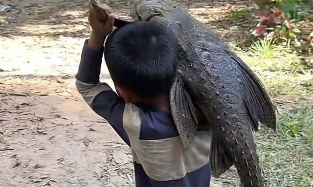 Clip: Cậu bé bắt được con cá có hình thù kỳ lạ, vác đi khắp làng, người dân hoảng hốt