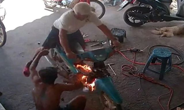 Clip: Xe máy bốc cháy dữ dội ngay sau khi khởi động, hai người thợ hoảng sợ tháo chạy