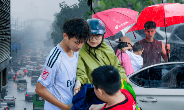 Hà Nội đang nắng gắt bỗng tối sầm, mưa như trút nước giữa trưa khiến người đi đường không kịp trở tay