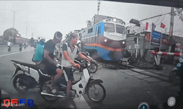 Cận cảnh người đàn ông lách qua khe hở hàng rào, 