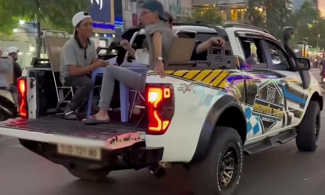 Nhóm thanh niên kê bàn ghế, ngồi ăn trên thùng xe bán tải đang chạy ở TP.HCM