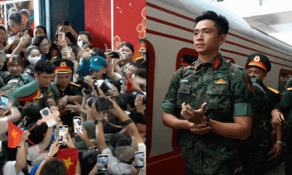 Thượng úy Lê Hoàng Hiệp được các chiến sĩ khác “hộ tống” di chuyển ra khỏi vòng vây của đông đảo người dân tại ga Hà Nội