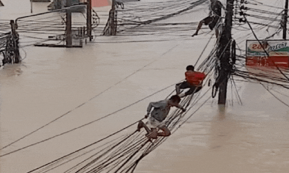 Bàng hoàng cảnh người dân Thái Lan leo dây điện để chạy lũ