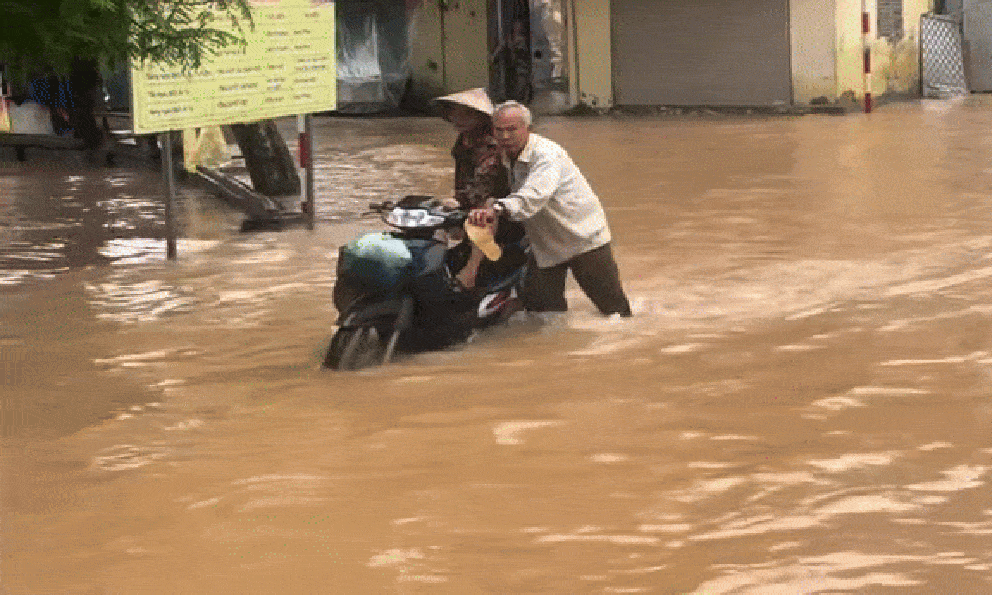 Clip cụ ông 70 tuổi đẩy xe chở vợ đi giữa dòng nước ngập tới gối ở Hà Nội: Hé lộ câu chuyện phía sau