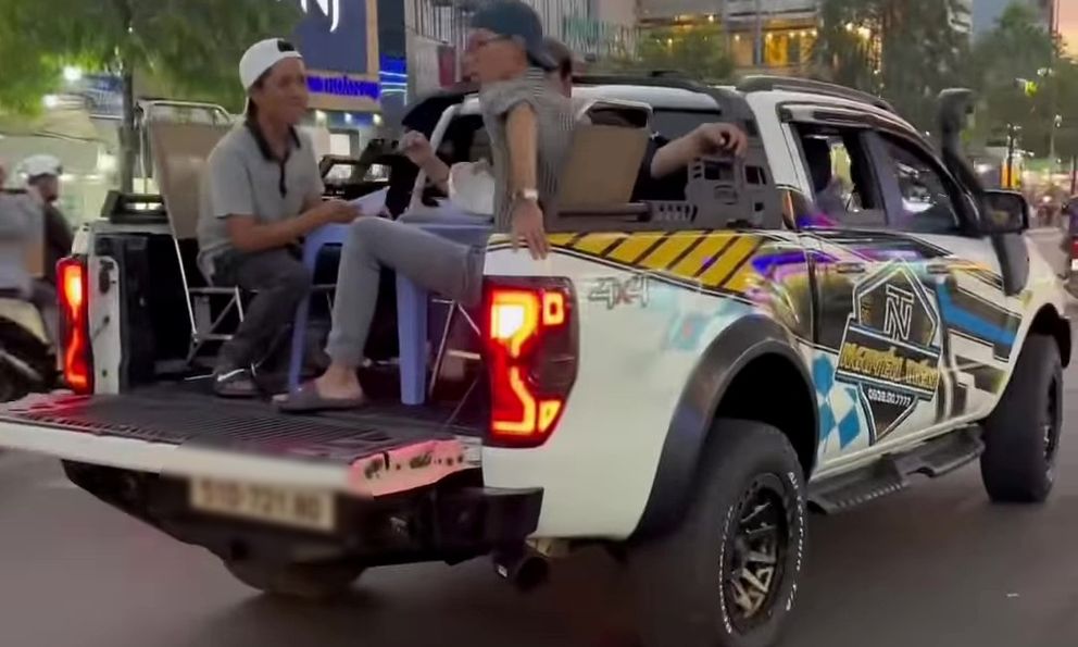 Nhóm thanh niên kê bàn ghế, ngồi ăn trên thùng xe bán tải đang chạy ở TP.HCM
